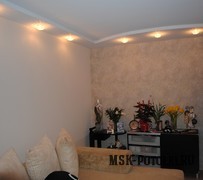 Бежевый двухуровневый натяжной потолок с точечным освещением в комнате с обоями
